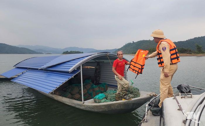 Cảnh sát giao thông phát áo phao cho nhân viên lái thuyền.