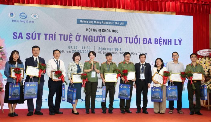Thiếu tướng Dương Thị Thu Hằng và PGS.TS.BS Lê Đình Thanh, Giám đốc Bệnh viện Thống Nhất tặng hoa cho các báo cáo viên.