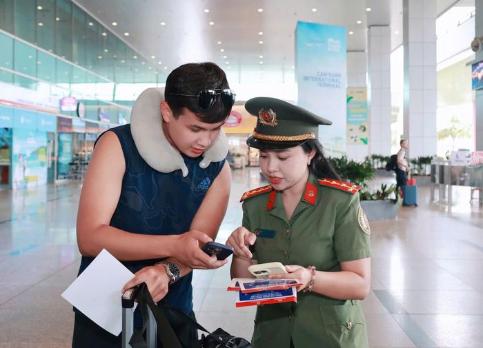 Cán bộ Phòng QLXNC Công an tỉnh Khánh Hòa tận tình hướng dẫn du khách quét mã QR để sử dụng phần “Trợ lý ảo du lịch Khánh Hòa”.
