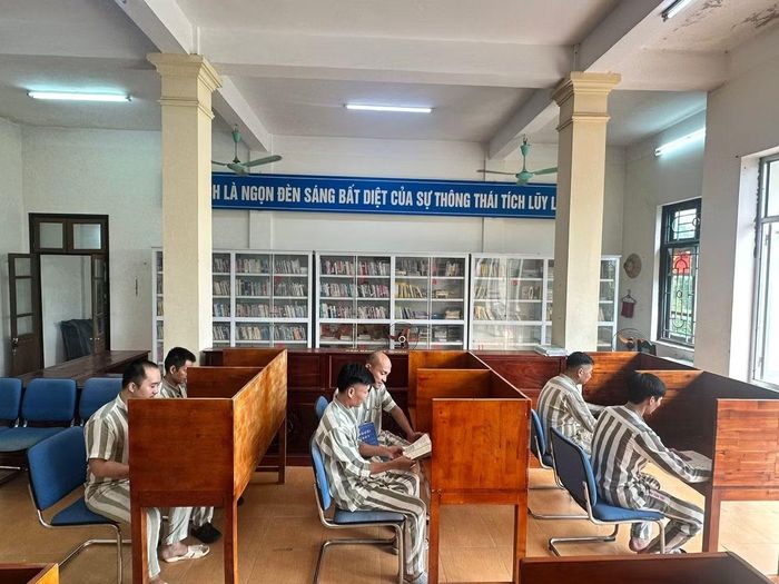 Các phạm nhân đọc sách, báo tại thư viện Trại giam Nam Hà.
