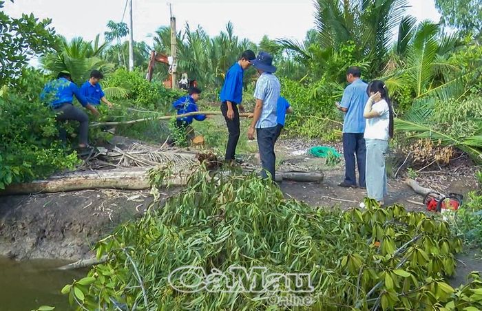Lực lượng đoàn thể cùng người dân tích cực phát quang bụi rậm để làm lộ đất đen trên tuyến Kênh 1.000 (Ấp 2).