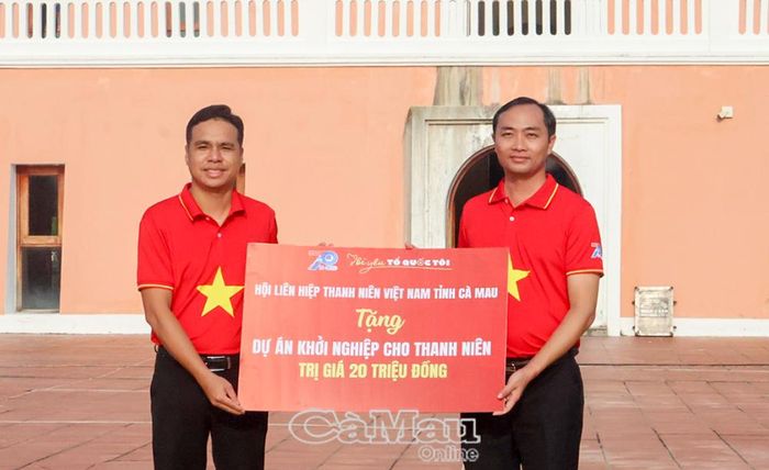  Phó Chủ tịch Uỷ ban MTTQ Việt Nam xã Đất Mũi, Bí thư Xã đoàn Mã Hữu Duyên (bên trái) tiếp nhận bảng tượng trưng tặng dự án khởi nghiệp từ Phó Chủ tịch Uỷ ban MTTQ Việt Nam tỉnh Cà Mau, Bí thư Tỉnh đoàn Phạm Tuấn Tài.