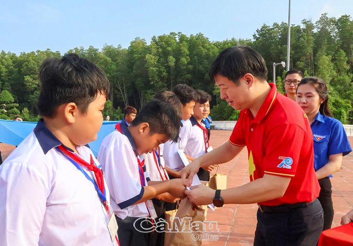 Phó Chủ tịch Thường trực Trung ương Hội LHTNVN Lê Hải Long trao quà cho các em học sinh tại xã Đất Mũi.