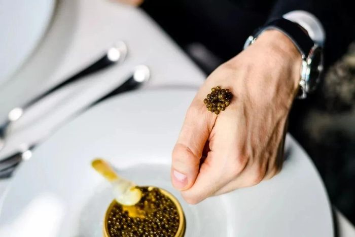 Thưởng thức trứng cá tầm bằng cách đặt lên tay để giữ hương vị nguyên bản nhất. (Ảnh: iStock)