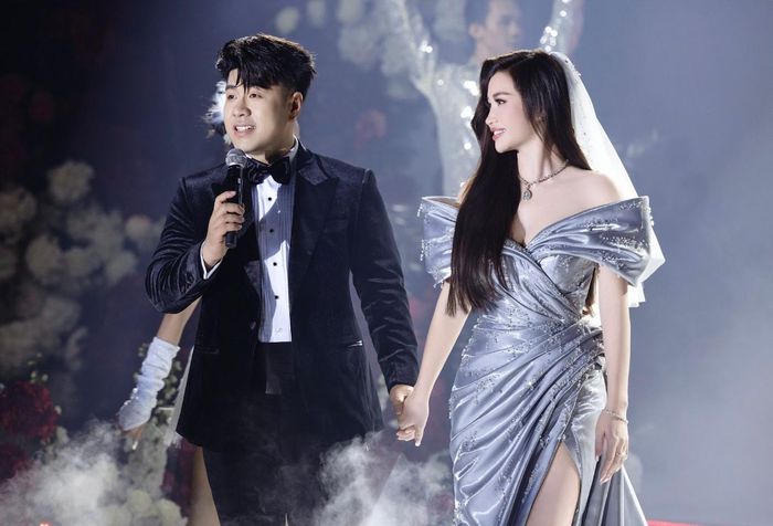 Trang phục ôm sát thân, nhiều nếp gấp và tạo khối, ưu tiên sự gọn nhẹ để cô dâu linh hoạt giao lưu với khách mời. Điểm nhấn trên bề mặt váy là các viên pha lê được đính thủ công theo hình giọt nước tượng trưng cho "những giọt nước mắt hạnh phúc" trong ngày cưới. 