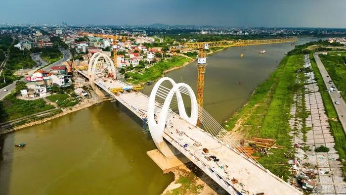 Nhìn từ thân vòm thép xuống, từng bó vật tư, sắt thép vẫn nằm ngổn ngang chờ lắp đặt. Nhịp độ công trường không có dấu hiệu hạ nhiệt sau mốc hợp long cuối tháng 9.