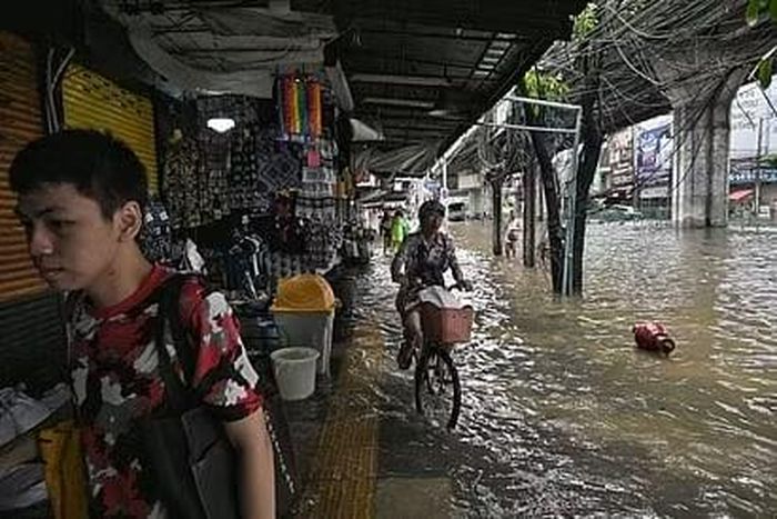 Người dân lội nước đi mua thực phẩm tươi sống và các mặt hàng thiết yếu để phục vụ cuộc sống hàng ngày
