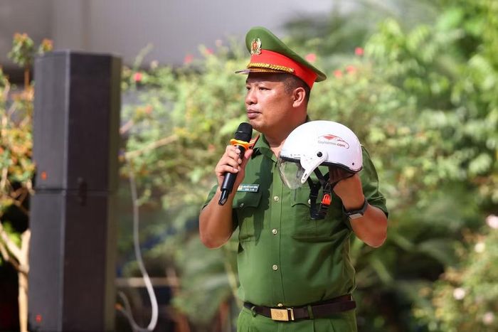 Trung tá Nguyễn Mạnh Hùng hướng dẫn học sinh cách kiểm tra tem hợp quy CR và cấu tạo 3 lớp tiêu chuẩn của một chiếc mũ bảo hiểm an toàn