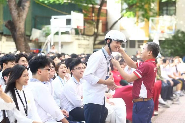 Học sinh trường THPT Kim Liên hào hứng tham gia trả lời câu hỏi và nhận phần quà là những chiếc mũ bảo hiểm đạt chuẩn.