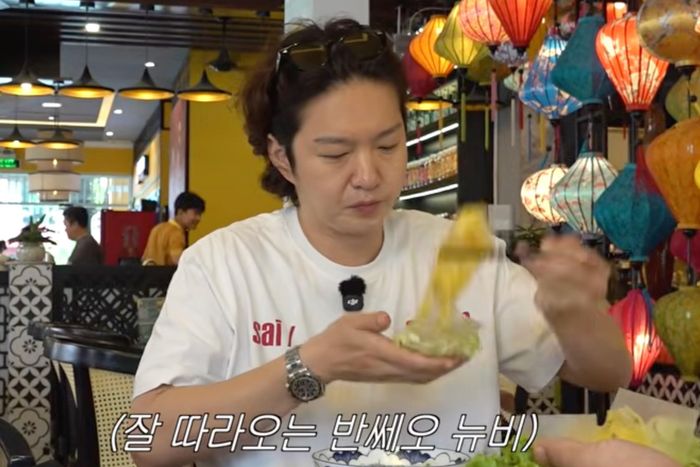 Vị khách Hàn Quốc cuốn bánh xèo "điệu nghệ". Ảnh: Cắt từ video.