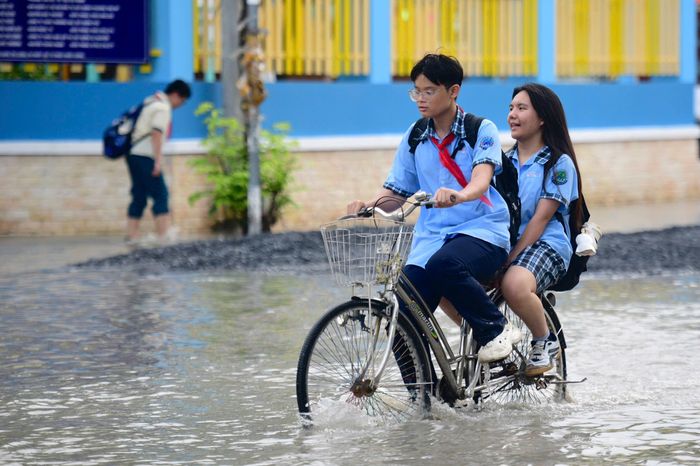 Người đi bộ lội qua đường 15B, đoạn trước khu chung cư Đức Khải. Nước ngập khiến người tham gia giao thông đi chậm lại, cẩn trọng vì sợ té ngã.