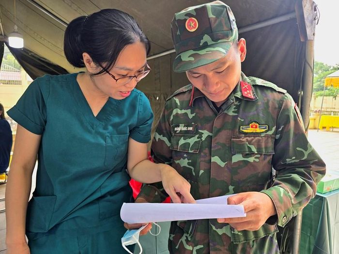 Bác sĩ Trịnh Thị Thủy và cán bộ làm nhiệm vụ số hóa trao đổi công việc trước khi khai quật lấy mẫu giám định ADN hài cốt liệt sĩ tại Nghĩa trang liệt sĩxã Phú Nghĩa