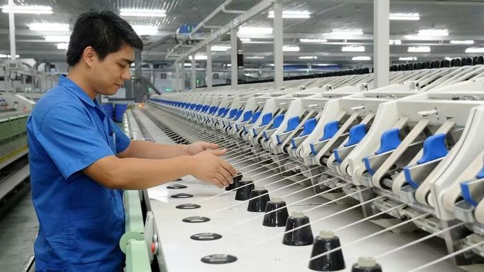 Công nhân Công ty trách nhiệm hữu hạn Một thành viên Dệt 8-3 vận hành dây chuyền sản xuất sợi. (Ảnh: TRẦN HẢI)