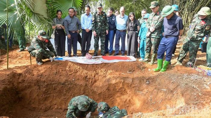 Lực lượng chức năng cất bốc hài cốt liệt sĩ tại khu vực đồi Đá Vôi, phường Cam Đường. (Ảnh: CÔNG HẢI)