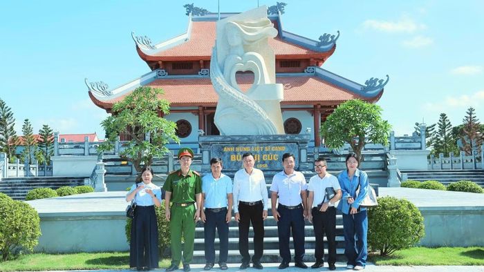 Đại diện lãnh đạo xã Xuân Trúc cùng đại diện lãnh đạo Công ty cổ phần Văn hóa đọc và học Việt Nam chụp hình lưu niệm tại Khu lưu niệm Anh hùng liệt sĩ Công an nhân dân Bùi Thị Cúc. (Ảnh: Thành Trung)