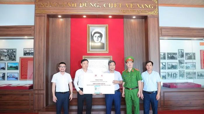Ông Nguyễn Xuân Thanh, Phó Giám đốc Công ty cổ phần Văn hóa đọc và học Việt Nam trao tặng 500 cuốn sách "Người chiến sĩ sống anh dũng, chết vẻ vang” tới đại diện lãnh đạo xã Xuân Trúc, tỉnh Hưng Yên. (Ảnh: Thành Trung)