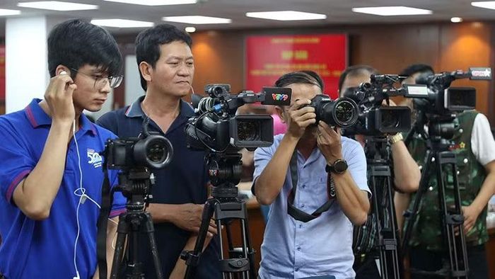 Phóng viên tác nghiệp tại một sự kiện ở trung tâm Thành phố Hồ Chí Minh. (Ảnh: HOÀNG TRIỀU)