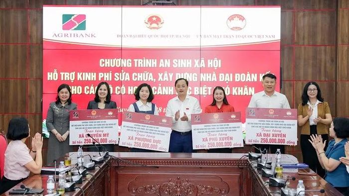 Đồng chí Tô Huy Vũ trao biểu trưng 1 tỷ đồng của Agribank hỗ trợ sửa chữa, xây dựng Nhà Đại đoàn kết cho các hộ gia đình có hoàn cảnh đặc biệt khó khăn.