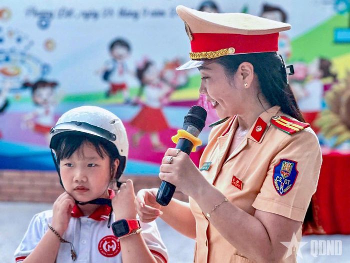 CSGT hướng dẫn học sinh sử dụng mũ bảo hiểm an toàn.