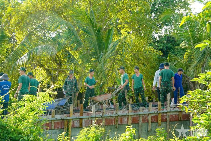 Cán bộ, chiến sĩ Lữ đoàn Pháo binh 6, Quân khu 9 giúp nhân dân làm cầu.