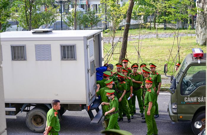  Các bị cáo di chuyển từ xe thùng chuyên dụng vào phòng xử. Ảnh: ĐỖ TRUNG 