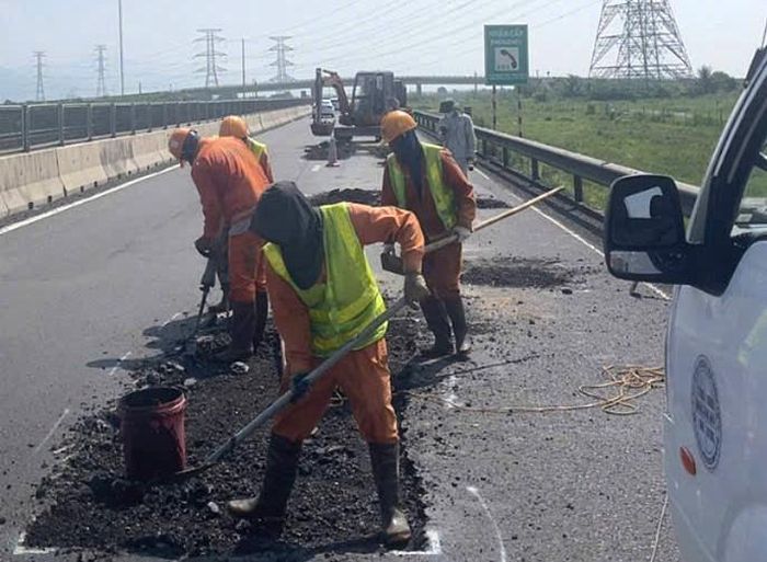  Sáng 28-9, nhiều công nhân đang dặm vá các vị trí hư hỏng trên đường cao tốc Vĩnh Hảo - Phan Thiết 