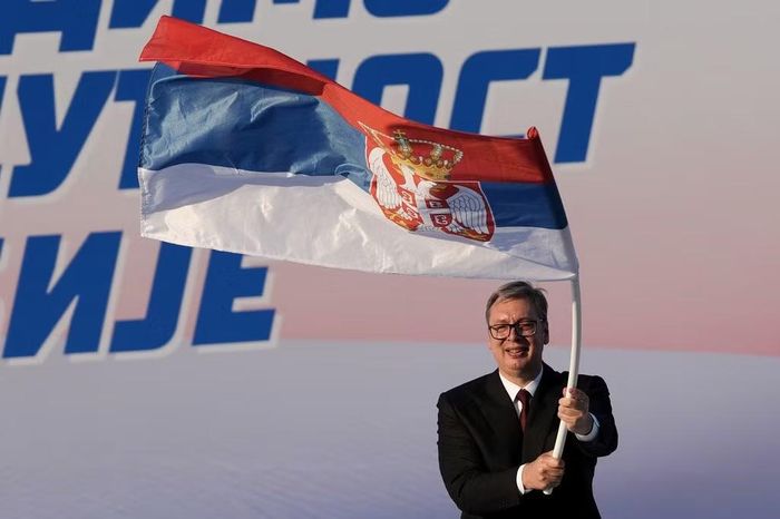 Tổng thống Serbia Aleksandar Vucic vẫy cờ Serbia trong một cuộc mít tinh của Đảng cầm quyền Serbian Progressive Party (SNS) tại Belgrade, Serbia, ngày 27/6/2026. Ảnh: AP/Darko Vojinovic.