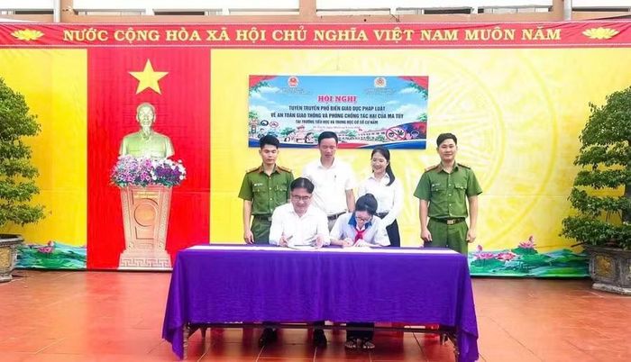 Đại diện Ban Giám hiệu và học sinh Trường Tiểu học và THCS Cự Nẫm ký cam kết chấp hành pháp luật.