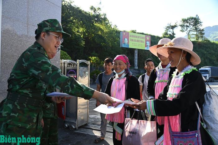 Cán bộ đội tuần tra phát tờ rơi tuyên truyền cho cư dân biên giới. Ảnh: Đức Duẩn