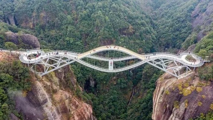 Không chỉ là một công trình phục vụ du lịch, cầu Như Ý còn được xem là điểm nhấn kiến trúc giữa cảnh quan núi non của Thần Tiên Cư. Những đường cong mềm mại của cây cầu tương phản với các vách đá dựng đứng, tạo nên khung cảnh đặc biệt khi nhìn từ xa. Du khách có thể tiếp cận cầu Như Ý bằng cáp treo từ khu vực phía Nam hoặc phía Bắc của khu thắng cảnh. Tuy nhiên, phần lớn du khách thường đưa điểm đến này vào hành trình khám phá toàn bộ Thần Tiên Cư thay vì chỉ tham quan riêng cây cầu. Ảnh: SMH.