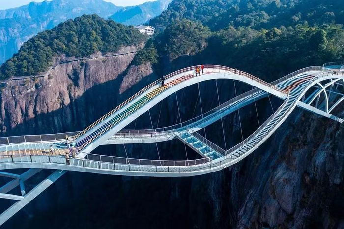 Phần phía trên của cầu sử dụng các tấm sắt đục lỗ, tầng phía dưới được thiết kế bằng kính trong suốt. Sự kết hợp này tạo cảm giác chênh vênh cho du khách khi đứng trên cầu, đặc biệt khi nhìn xuống vực sâu bên dưới. Với những người sợ độ cao, trải nghiệm bước trên lớp kính trong suốt ở 140m có thể là một thử thách không nhỏ. Ảnh: HighestBridges.com.