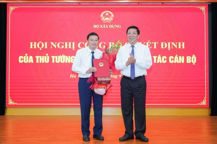  Bộ trưởng Trần Hồng Minh trao quyết định và tặng hoa chúc mừng tân Thứ trưởng Lê Hồng Vinh. Ảnh: Tạp chí Xây dựng 