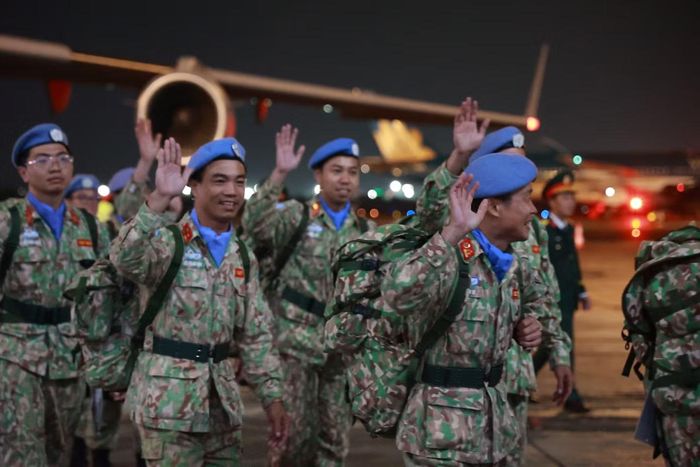 Dưới cơn mưa nặng hạt, hàng chục người thân hướng mắt về phía đường băng đón những người lính mũ nồi xanh trở về sau một năm thực hiện nhiệm vụ gìn giữ hòa bình tại Nam Sudan.