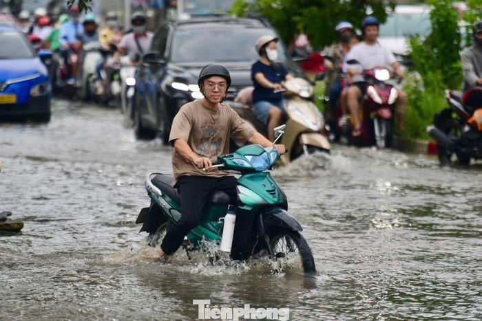 Tại đường Phạm Hữu Lầu, đoạn giao với đường 15B, nước dâng cao khiến các phương tiện di chuyển khó khăn, giao thông ùn ứ cục bộ.
