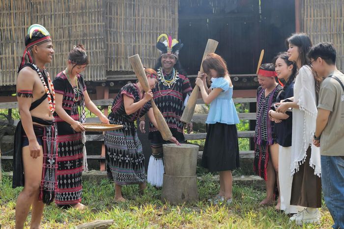 Du khách trải nghiệm giã gạo trong không gian văn hóa Cơ Tu dưới sự hướng dẫn của già A Lăng Đợi.