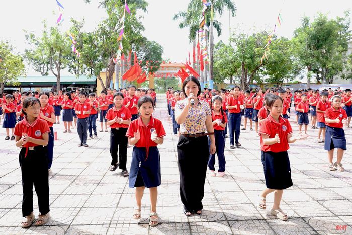 Cô giáo Thái Thị Thu Thủy hướng dẫn học sinh tham gia hoạt động thể dục giữa giờ.