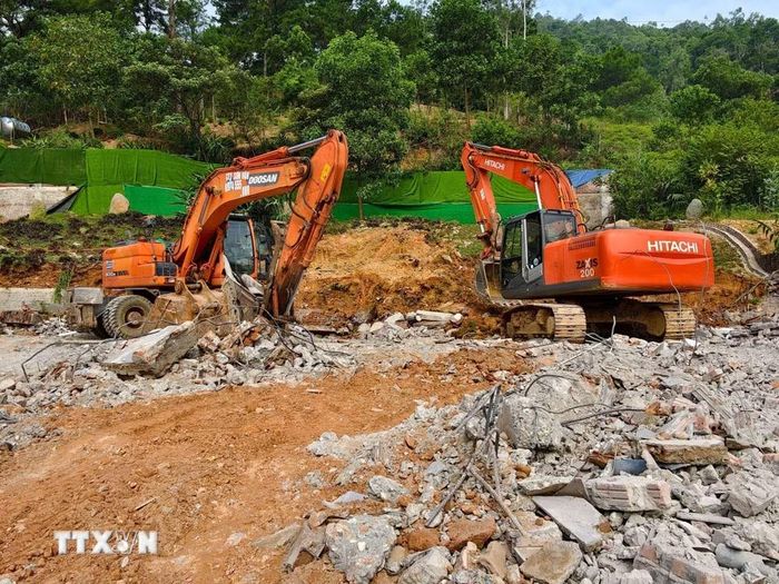 Máy xúc và xe tải được huy động vận chuyển phế thải trong quá trình cưỡng chế công trình vi phạm tại thôn Thái Vụ. (Ảnh: Trung Nguyên/TTXVN)
