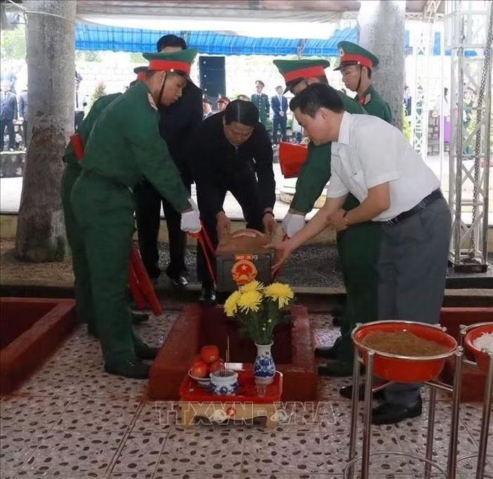 Các đại biểu thực hiện nghi thức an táng liệt sĩ tại nghĩa trang Hòn Dung. Ảnh: Xuân Triệu/TTXVN