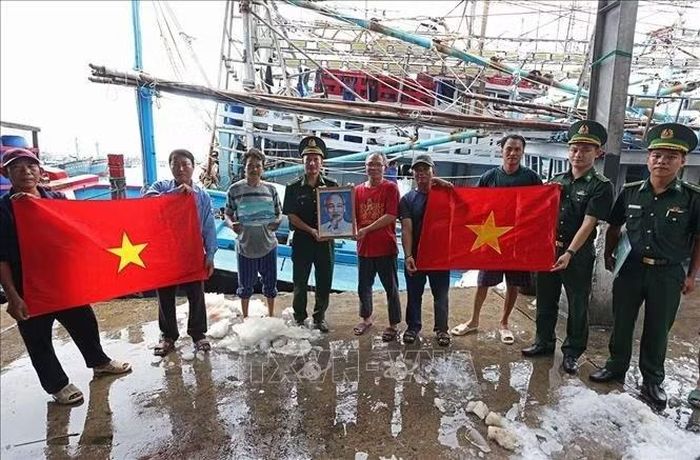 Bộ đội Biên phòng phối hợp với các lực lượng chức năng tổ chức tuyên truyền, tặng cờ Tổ quốc và ảnh Bác Hồ cho ngư dân trước khi vươn khơi bám biển tại cảng Hòn Rớ ở phường Nam Nha Trang, tỉnh Khánh Hoà. Ảnh: Vũ Sinh/TTXVN.