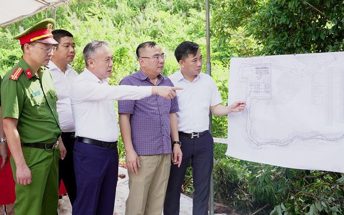Lãnh đạo NPMB báo cáo lãnh đạo xã Hải Ninh về tiến độ giải phóng mặt bằng dự án. Ảnh: Hương Thủy/BNEWS/TTXVN
