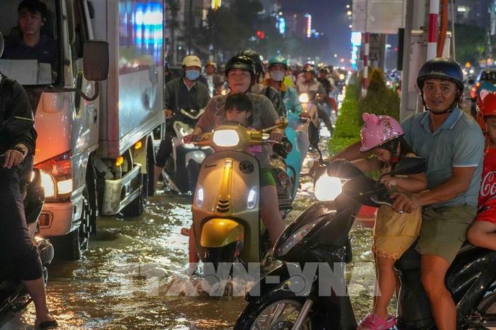 Triều cường vượt báo động III gây ngập sâu, ảnh hưởng đến việc đi lại của người dân. Ảnh: Thanh Liêm - TTXVN
