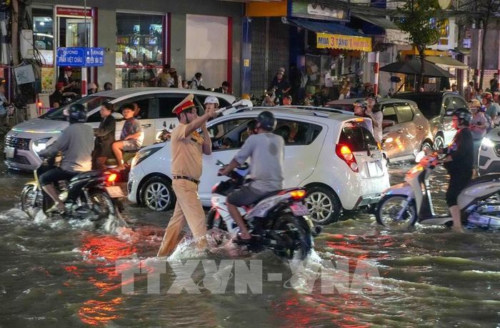 Lực lượng Cảnh sát giao thông có mặt điều tiết, phân luồng giao thông trên đường Nguyễn Văn Cừ tối 28/9. Ảnh: Thanh Liêm - TTXVN