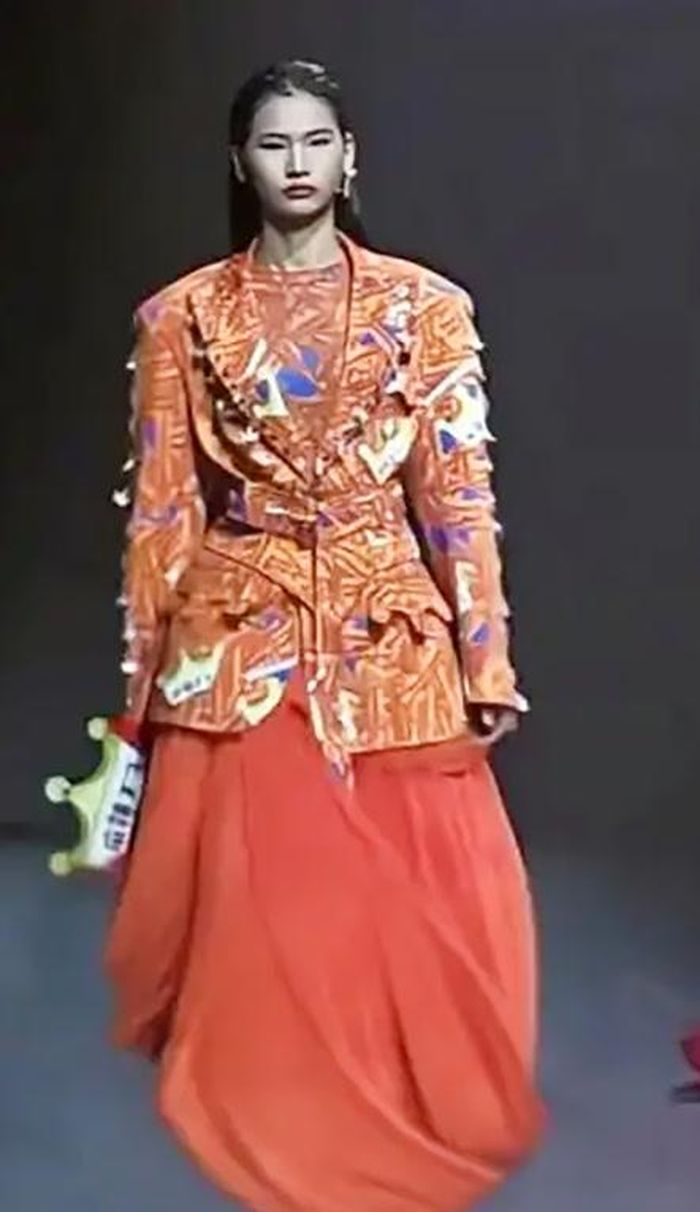 Leng có màn ra mắt trên sàn diễn tại sự kiện SS26 Fashion Source ở Thâm Quyến, nhận được những tràng pháo tay nhiệt tình khi xuất hiện trong bộ trang phục màu cam lấy cảm hứng từ món ăn vặt nổi tiếng latiao (thanh cay). Ảnh: Baidu.