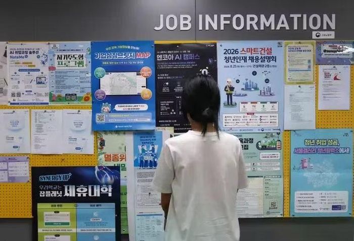 Một sinh viên đại học đang tìm kiếm các cơ hội việc làm trên bảng thông tin ở Seoul, Hàn Quốc