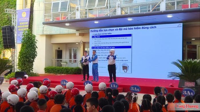 Các em học sinh thích thú khi được hướng dẫn lựa chọn và đội mũ bảo hiểm đúng cách.