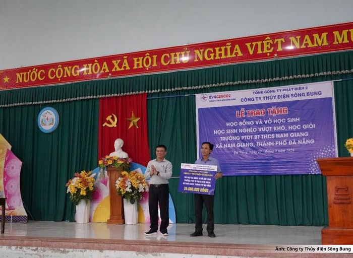 Đại diện Công ty Thủy điện Sông Bung trao biểu trưng cho đại diện Trường Phổ thông Dân tộc bán trú Trung học cơ sở Nam Giang. 