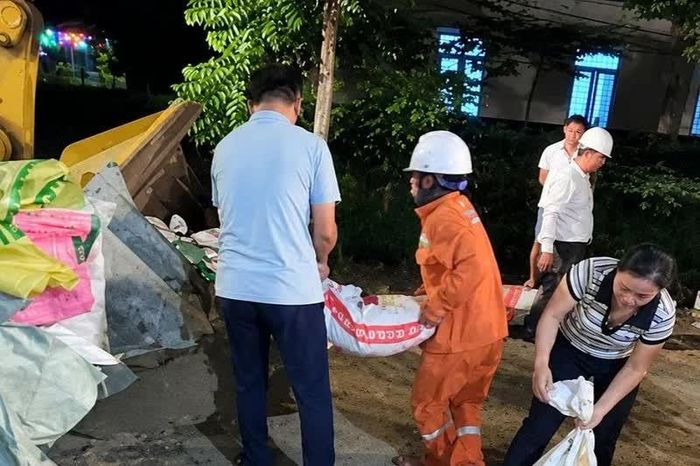 Cán bộ, nhân viên Điện lực Triệu Sơn cùng các lực lượng tham gia gia cố, bảo vệ các vị trí có nguy cơ bị nước tràn.