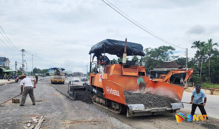 Nhà thầu thi công thảm cấp phối đá dăm, tiến hành lu tĩnh nền đường. Ảnh: TÚ QUỐC