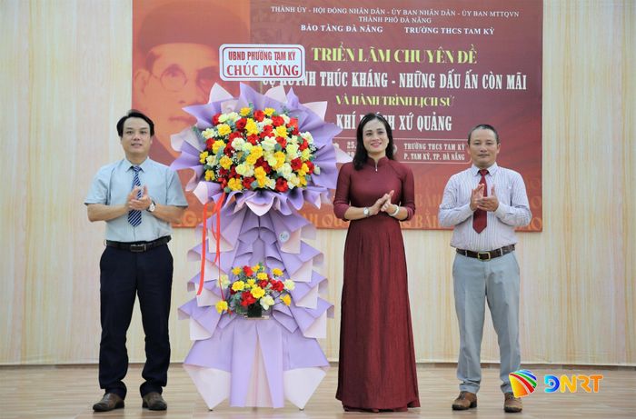 Đại diện lãnh đạo UBND phường Tam Kỳ (bìa trái) tặng hoa chúc mừng triển lãm. Ảnh: ALĂNG NGƯỚC