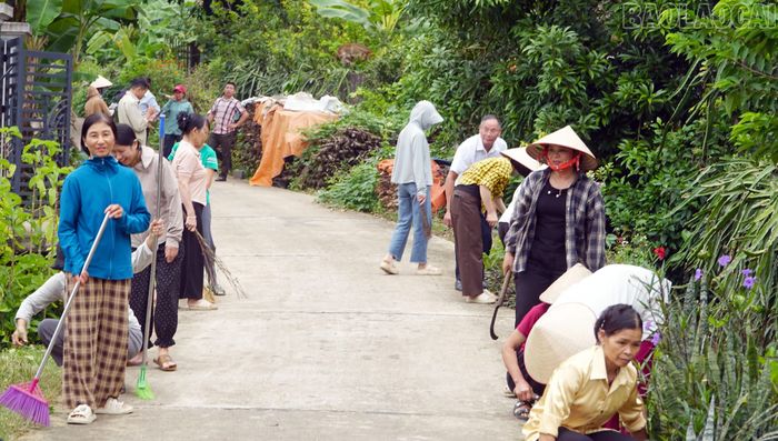 Người dân thôn Đồng Khê quét dọn, vệ sinh môi trường đường thôn.